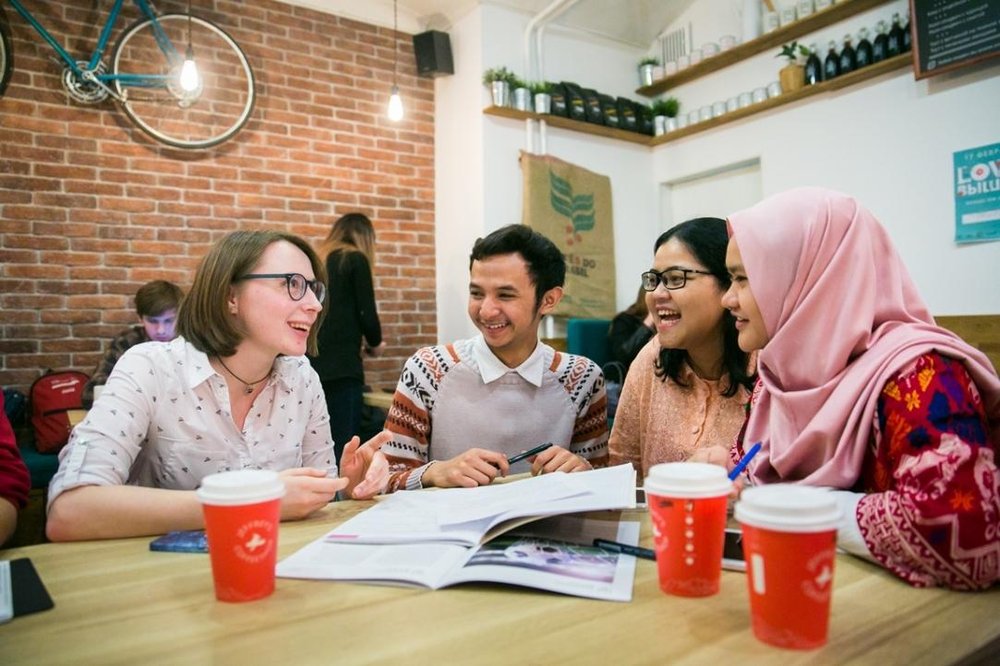 un groupe d'étudiants internationaux échange autour d'un café