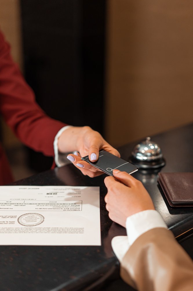 Retrait du DEC en tourisme du permis de travail postdiplôme : ce que cela change pour les étudiants étrangers au Québec une réceptionniste d'hôtel accueille des clients à la réception